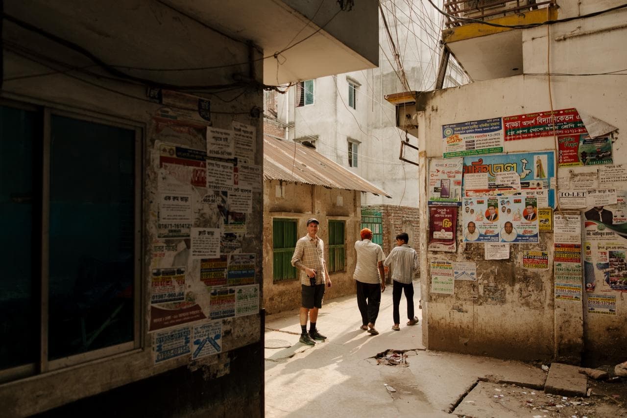Sam Morgan walking through a narrow alleyway on location, documentary-style