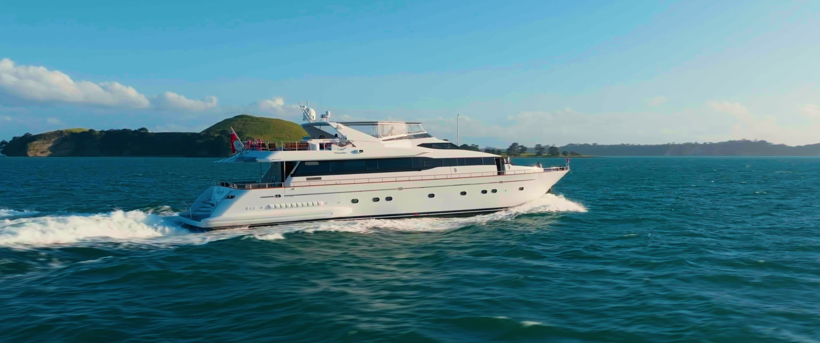 The superyacht Liberté cruising past an island near Auckland