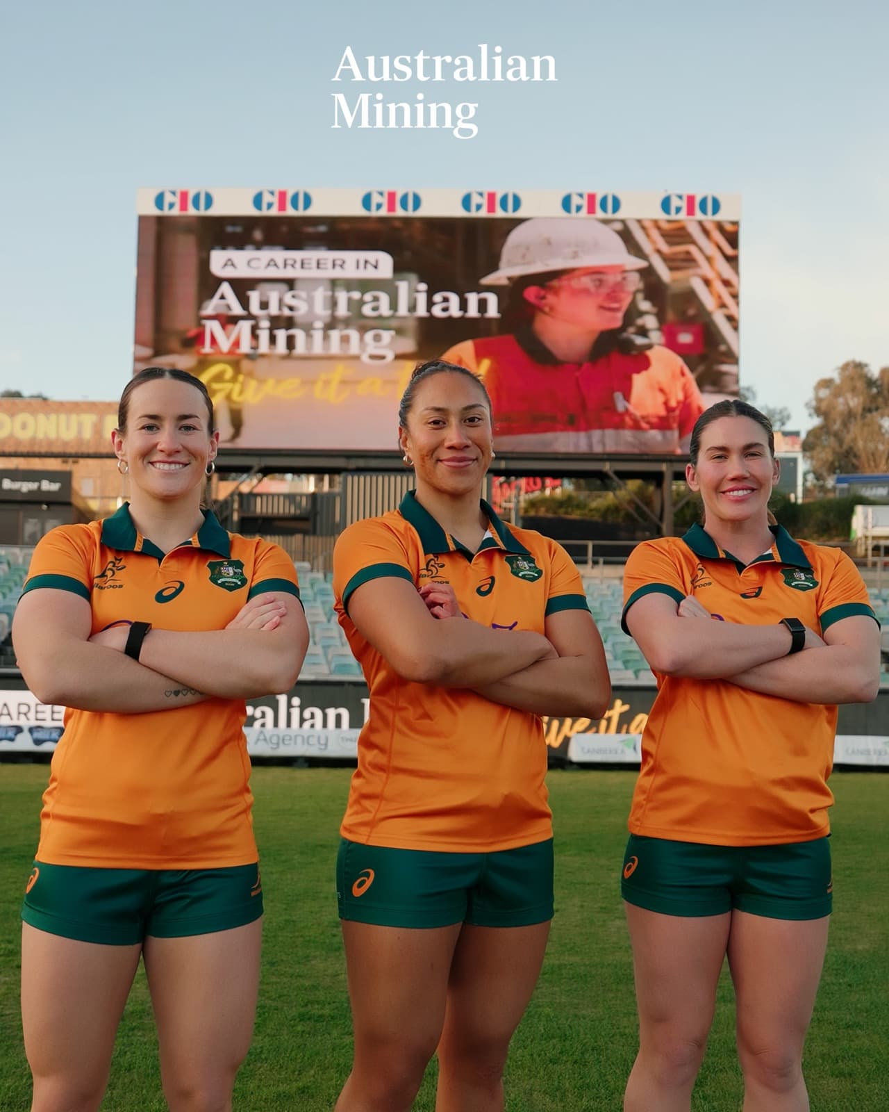 Wallaroos players standing arms crossed on the pitch at GIO Stadium, Canberra, in front of the 'A Career in Australian Mining' big screen