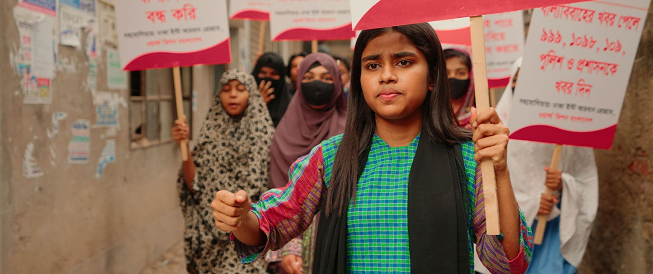 Girl holding an awareness campaign sign in a march, Bangladesh