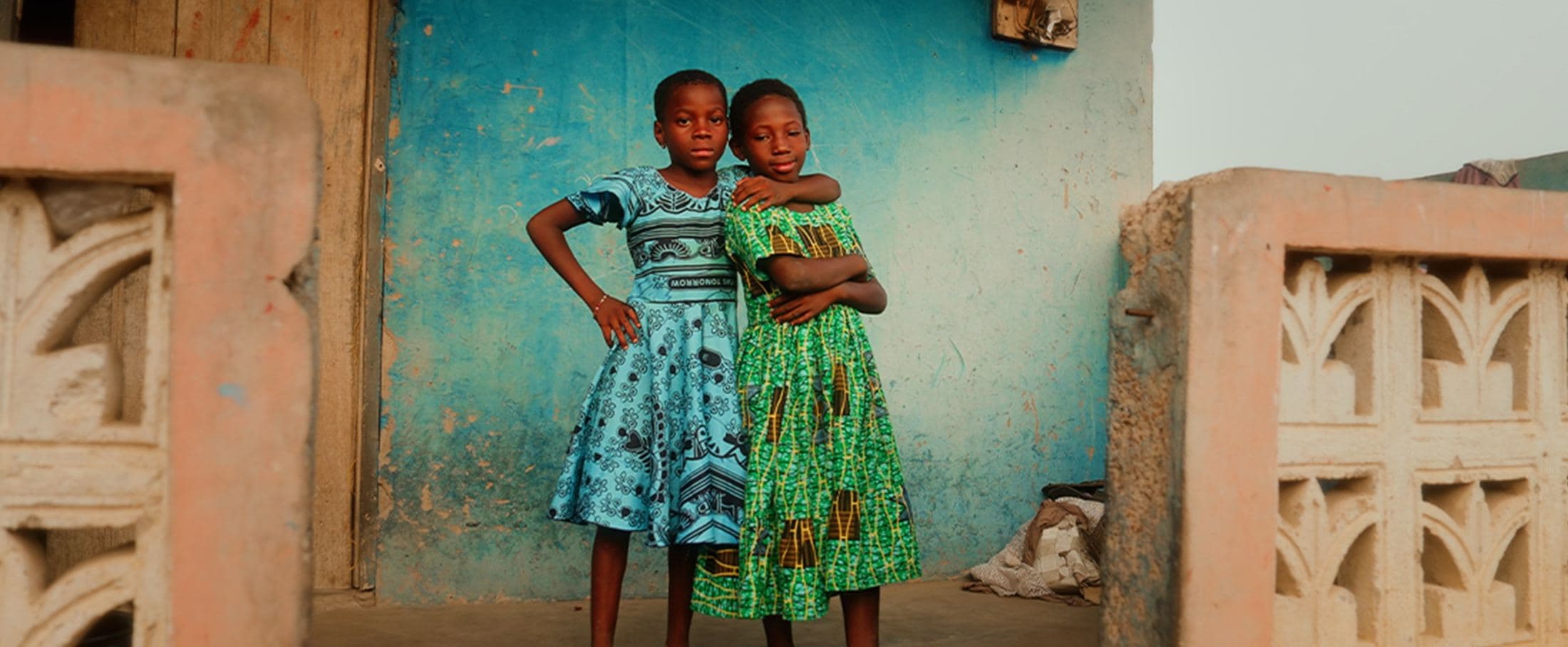 Two girls against a blue wall, Ghana