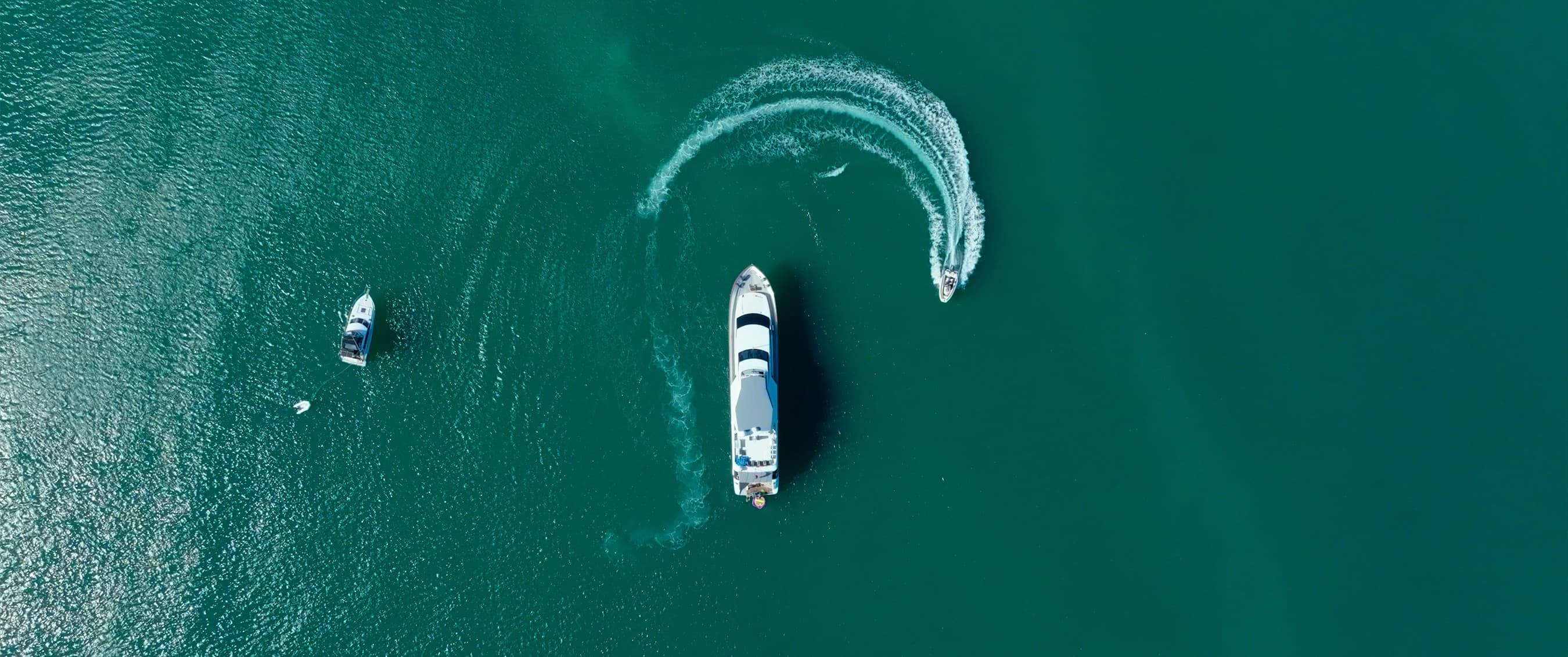 Aerial shot of a kitesurfer near the yacht